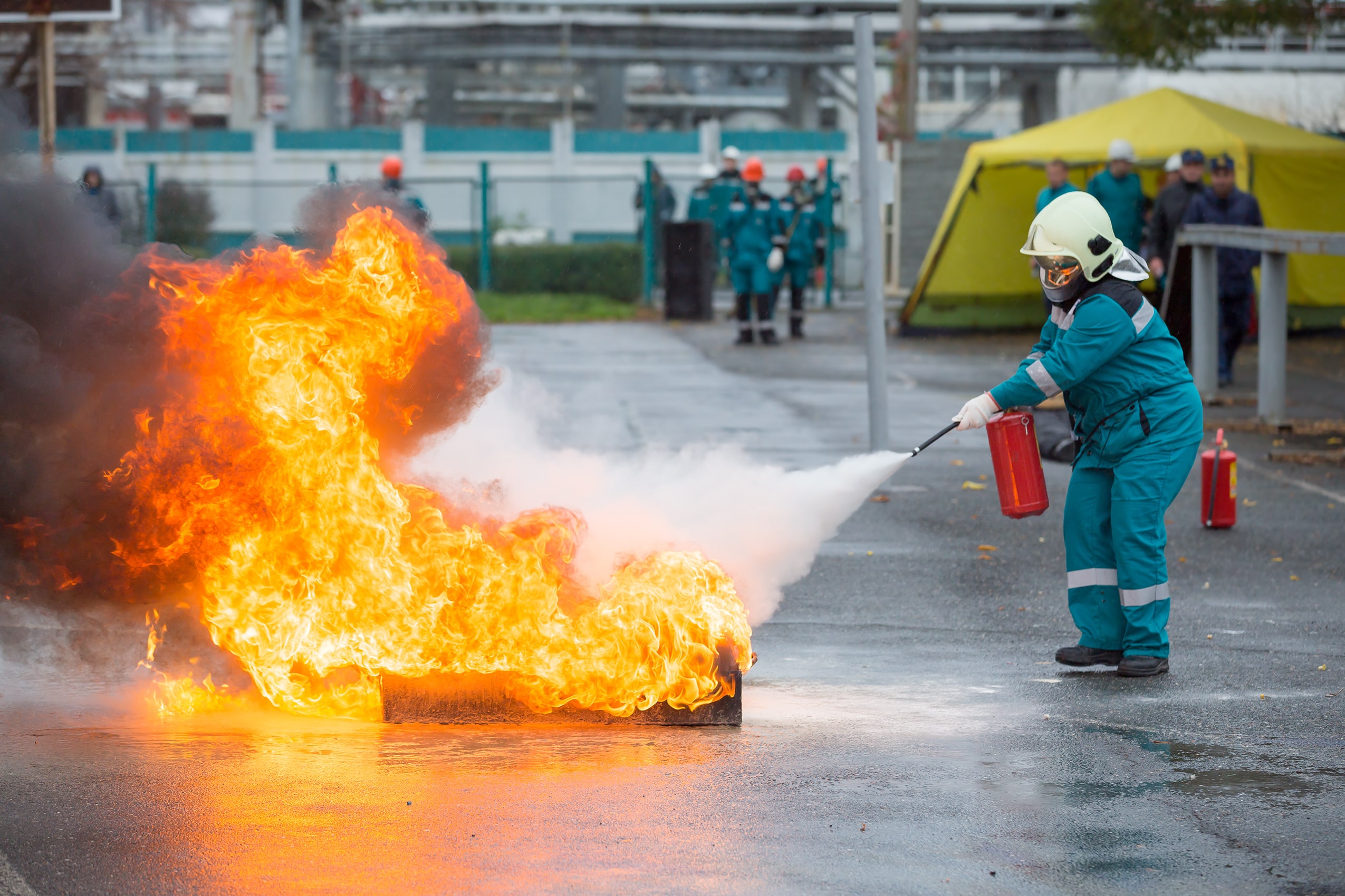 Fireman extinguishing a fire with fire extinguisher